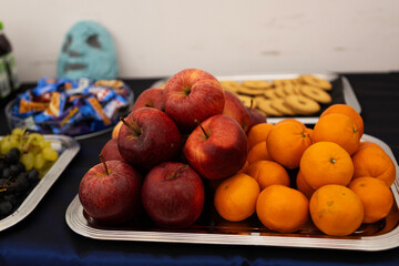 Freshly arranged apples and oranges served on a tray during a casual gathering at a community event in the afternoon