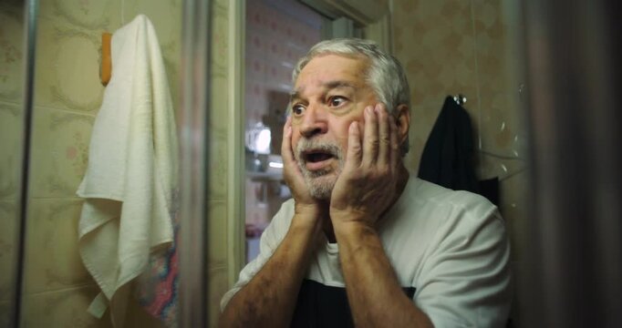 Older man cupping face in shock, mouth open, eyes wide with disbelief and fear, a powerful moment of emotional intensity and personal realization