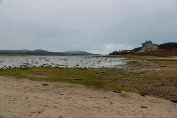 A dramatic and atmospheric photograph of the ruined medieval Castle Tioram (pronounced "Cheerum"), the former stronghold of the Clanranald branch of the MacDonalds - in Loch Moidart