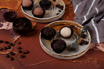 Candies made from dried fruits and nuts on a ceramic plate. Healthy dessert with coffee flavor