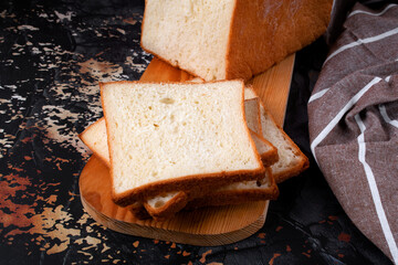Wheat toast bread sliced on wooden cutting board. Fresh baked loaf