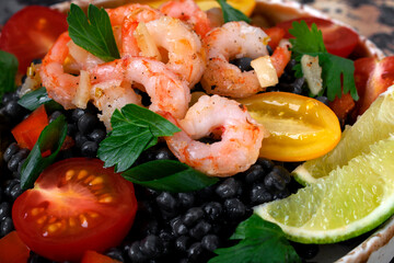 Black ptitim pasta served with shrimps and vegetables