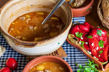 A warm bowl of cooked potato soup placed on a table, showcasing its creamy texture, soft vegetables, and homemade appearance. The natural lighting highlights the comforting and rustic feel of the dish