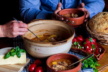 A warm bowl of cooked potato soup placed on a table, showcasing its creamy texture, soft vegetables, and homemade appearance. The natural lighting highlights the comforting and rustic feel of the dish