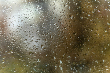 Close up of wet window with rain drops and soft light