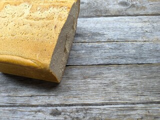 tasty piece of black bread lies on a wooden table