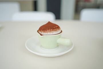 Homemade delicious chocolate pudding or mousse in a glass vase on a light slate.