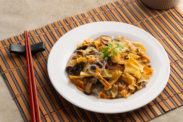 Stir fried Shiitake mushrooms, wood ear mushrooms, Chinese dried lily flower, glass noodles and tofu skin in a plate.(pad jay chay).five auspicious food pay homage to God of Wealth, God of Fortune.