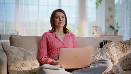 Distant manager browsing laptop developing project at home. Woman thinking work