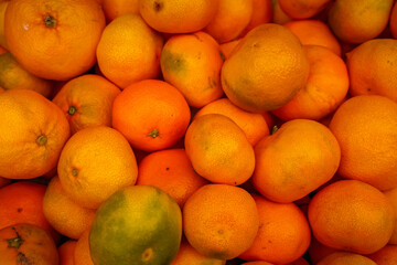 Close-up of fresh ripe oranges and mandarins with natural texture and vibrant color. Healthy citrus fruits background symbolizing vitamin C, freshness, and organic nutrition.