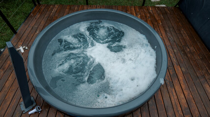 Relaxing outdoor hot tub with bubbling water on a wooden deck
