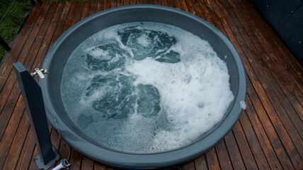 Relaxing outdoor hot tub with bubbling water and wooden deck