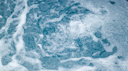 Abstract view of bubbling water with foam and bubbles in shades of blue
