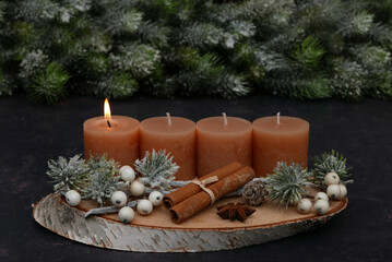 First Advent: Natural Advent decoration with fir branches, cinnamon sticks, and brown candles.