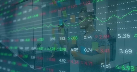 Analyst entering office responding to transparent financial data overlay and adjusting sticky notes - Powered by Adobe