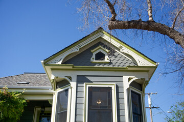 Victorian architecture detail featuring ornate trim and pastel tones under a bright blue California sky.