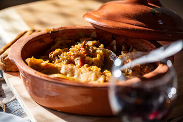 A bowl of cooked cabbage served in a rustic brown dish, showcasing its soft texture and warm, comforting appearance. The natural colors and simple presentation make this image suitable for traditional