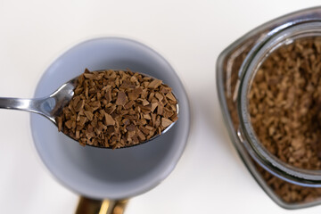 Close-up of instant coffee on a spoon ready to be mixed
