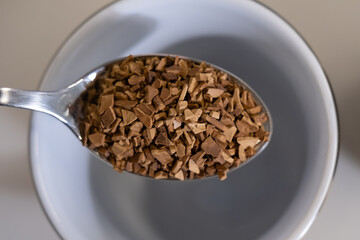 Close-up of instant coffee on a spoon ready to be mixed