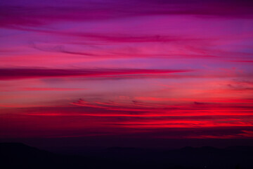 A winter sky glows with deep blues and soft pinks, merging into violet at sunset, evoking the moods of All Saints Day, Halloween, and the hope of Easter.