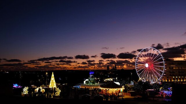 Aerial view of Christmas decorations and ferris wheel in Valletta Malta cityscape at dusk. 