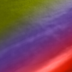 Vivid abstract gradient with blurred color transitions in green, purple, and red hues.