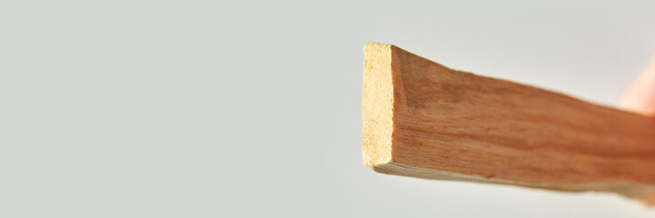 Close-up image of a wooden stick on a light background showcasing texture and detail.