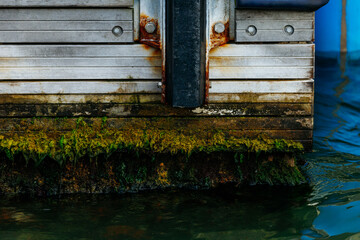 Rusty metal dock with algae in water