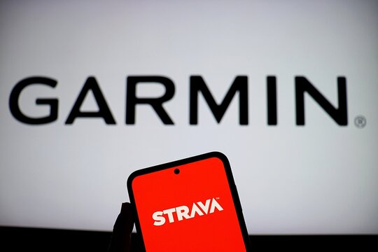 Salvador, Brazil - October 19, 2025: Strava app on smartphone screen with Garmin logo in the background. Strava and Garmin apps.