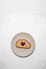 Slice of Bread with Heart-Shaped Jam on Striped Plate