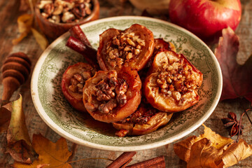 Baked apple with dried fruits, walnuts and honey in autumn rustic decor