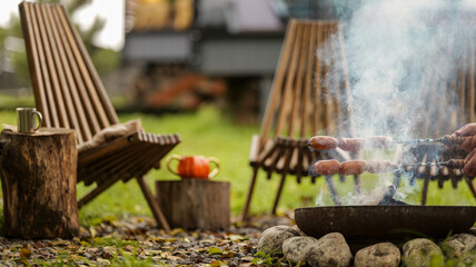 Cozy outdoor scene with grilling sausages, chairs, and a rustic autumn setting