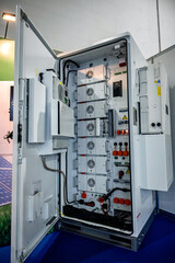 Modern energy storage system featuring an open cabinet revealing multiple battery modules and...