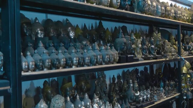 Black stone and bronze statues of Buddha and other Gods are sold on the flea market for memory of a trip to Siem Reap, Cambodia. Closeup. Shot in motion