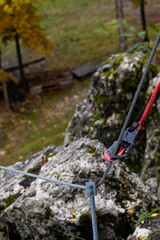Naklejka premium Double carabiner attached to a steel safety rope during climbing.