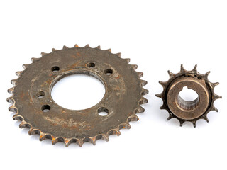 A close-up of a dirty, oily sprocket set against a white background. The image reflects maintenance.