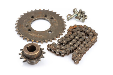 Close up of dirty, oily and greasy old motorcycle chain and sprocket set on white background. The image reflects the essence of repair, maintenance