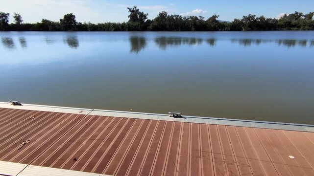 View of the Ebro River at its final stretch, flowing peacefully to its mouth in the Mediterranean Sea, in Catalonia. It is one of the longest and most voluminous rivers in Spain. POV + Pan right.