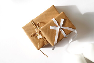Christmas. Gifts in Kraft Paper on White Background with Mockup Copy Space. Holidays Season. Gifting Concept.        