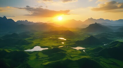 Aerial view of a lush valley with lakes and mountains at sunset time