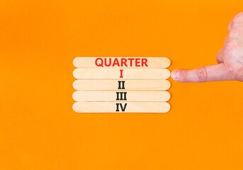 1st first quarter 1 symbol. Concept word Quarter 1 on beautiful wooden sticks. Beautiful orange background. Businessman's hand. Business, happy 1st first quarter 1 Q1 concept. Copy space.