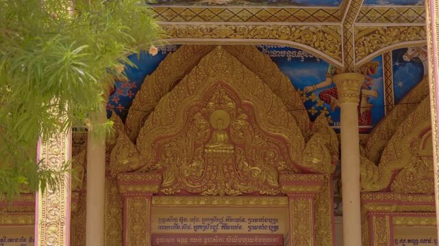 Golden chofas (serpent like roof decoration) on the tiled roof of Wat Kampong Phluk Buddhist temple are decorated with light garlands for celebration. Siem Reap, Cambodia. Shot in motion 