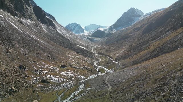 Aerial view of a mountain trail along a river leading to the moraine of the Bolshoi Ala-Archa Glacier. Location -  the end of Ala-Archa Gorge on the slope of the Kyrgyz Range.