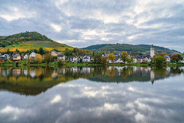 Fototapeta premium Bullay village at dawn with St. Mary's church reflected in Moselle river in Germany. Europe