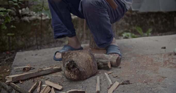 Watch a man skillfully chop wood outdoors, transforming logs into kindling with an axe. This video captures the satisfying sounds of rustic manual labor and preparation.