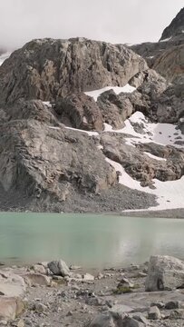 Serene Glacial Lake Reflects Majestic Rocky Mountains with Snow Patches in British Columbia, Canada