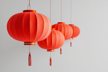 Obraz premium Red Chinese lanterns hanging in a row on white background.