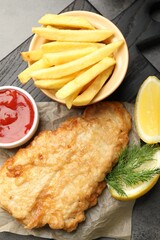British Traditional Fish and chips served with sauce on grey table, top view