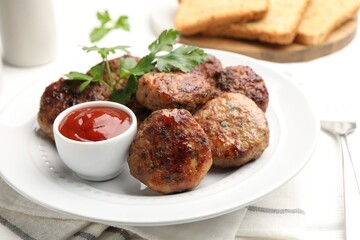 Delicious patties with parsley and ketchup on white table, closeup
