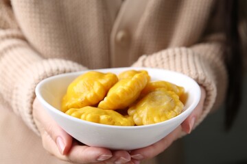 Woman with bowl of pickled pattypan squashes, closeup